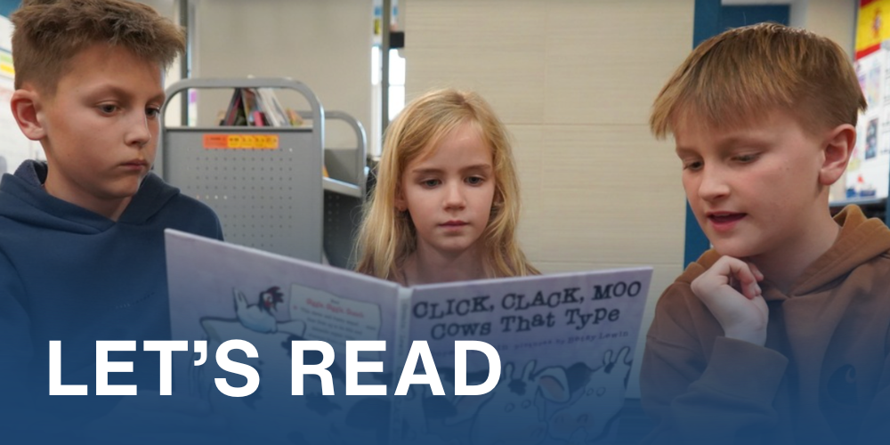 Let's Read. Students reading a book together.