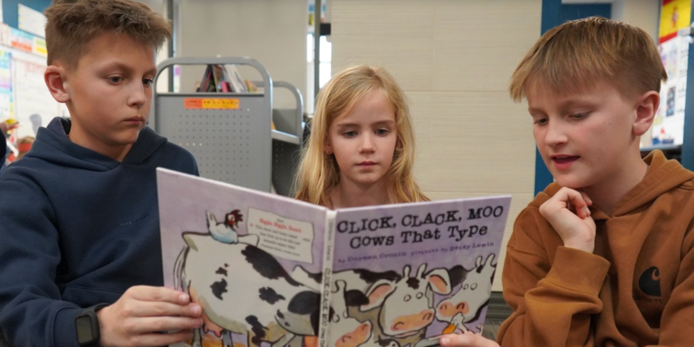Three students reading together.
