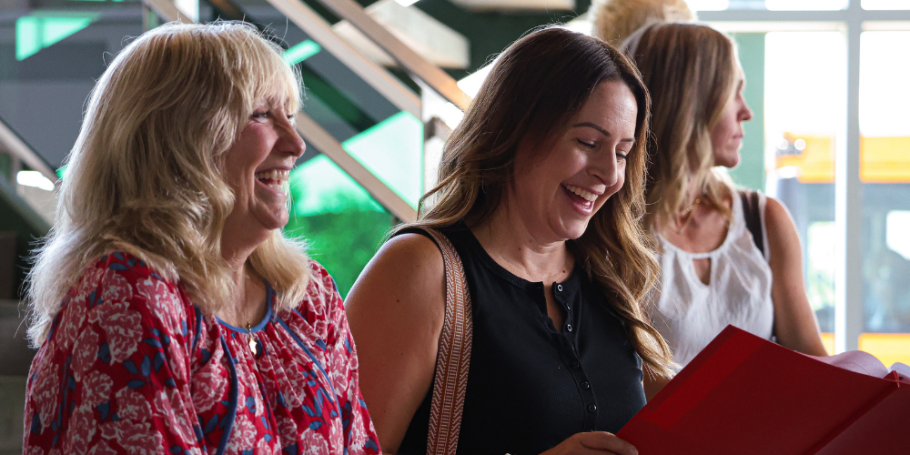 Board members smiling as they look over plans.