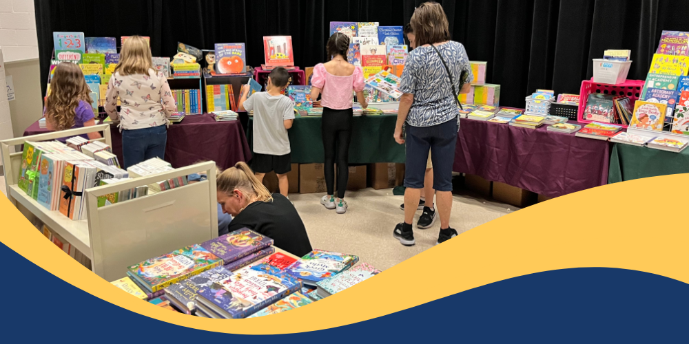 students and parents looking at book in the book fair