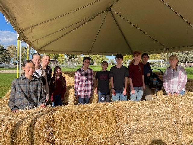 National Honor Society posing in a Hay Maze they created.