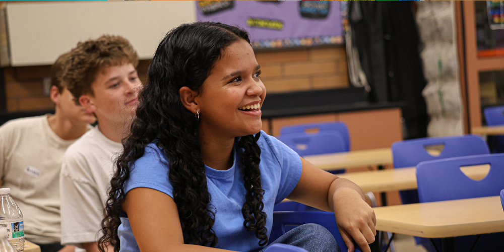 A student in class smiling.
