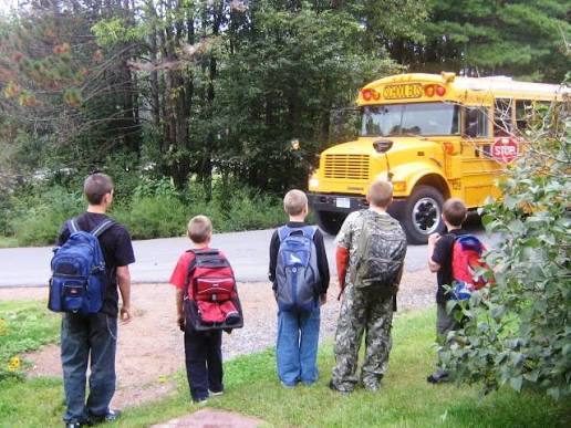Kids waiting for a  school bus to pull up