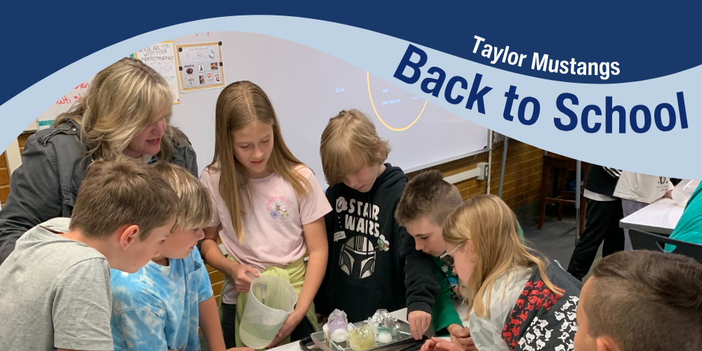 Blue background with text "Taylor Mustangs - Back to School." Image of teacher working with a small group of students on a science experiment.