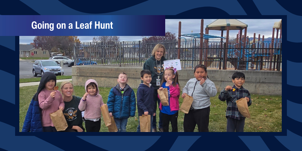 Students and teachers pose for a picture outside holding leaves.