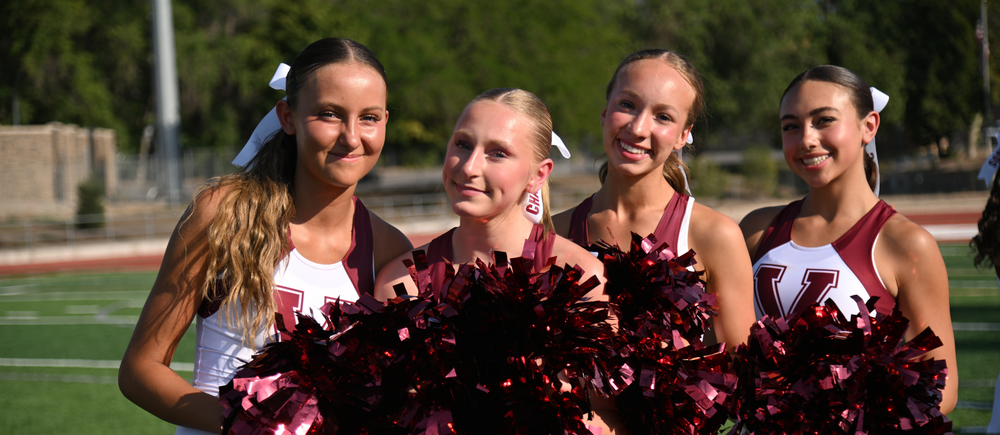cheerleaders with pom poms smiling