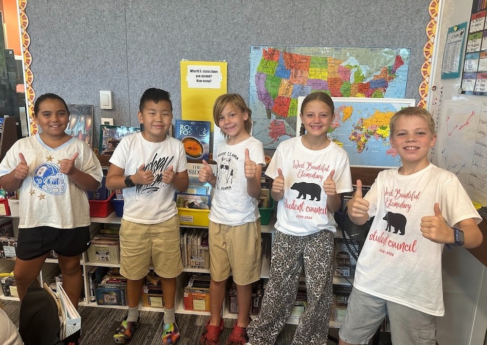 West Bountiful Elementary students in a classroom. 5 students are giving "thumbs up" to the camera.