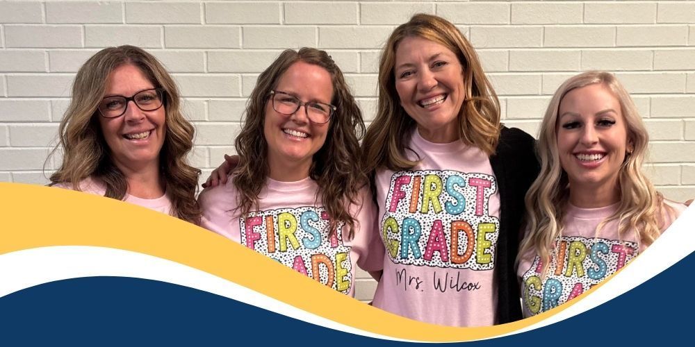 Picture of all 4 first grade teachers standing shoulder to shoulder wearing pink shirts that say "first grade" on them.