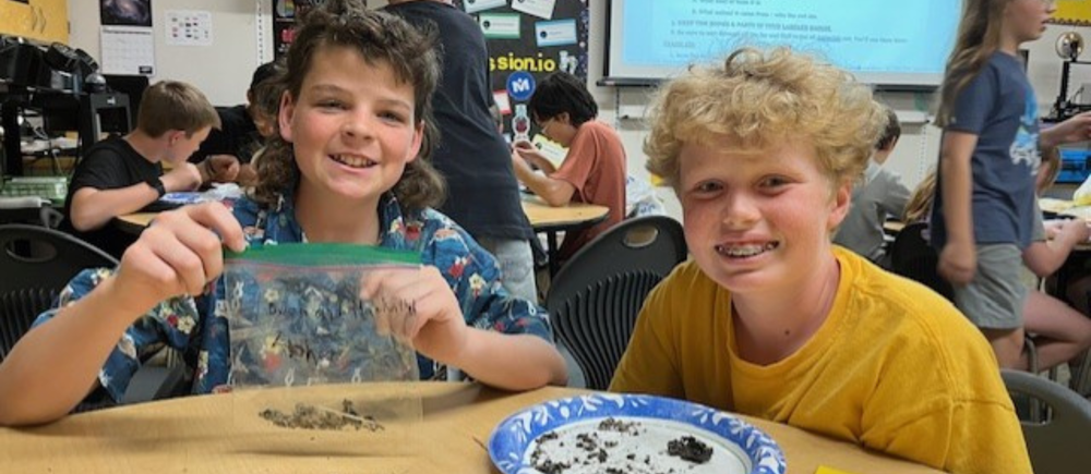 Two students at a table in a classroom dissecting owl pellets