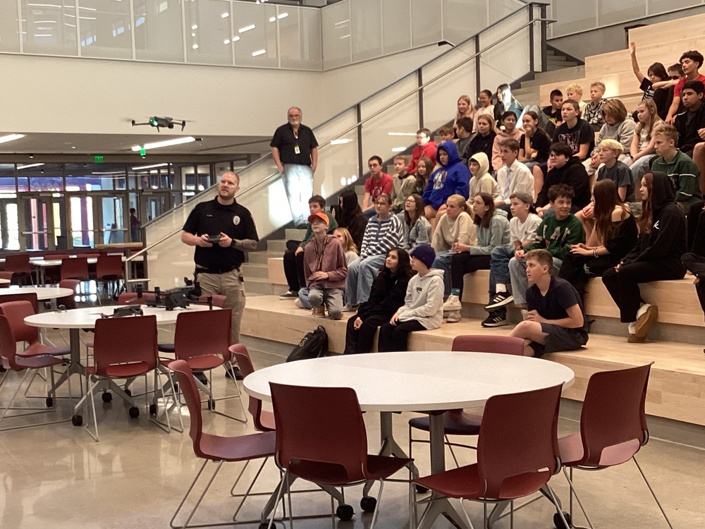Police officer showing students a drone