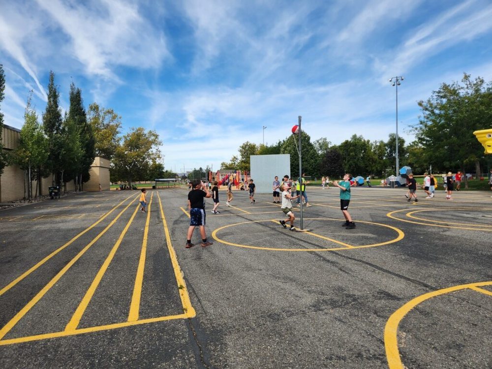 Students playing tetherball and four square