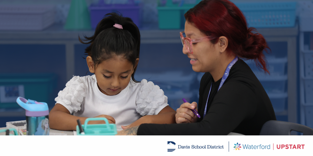 A student doing schoolwork with a helper.
