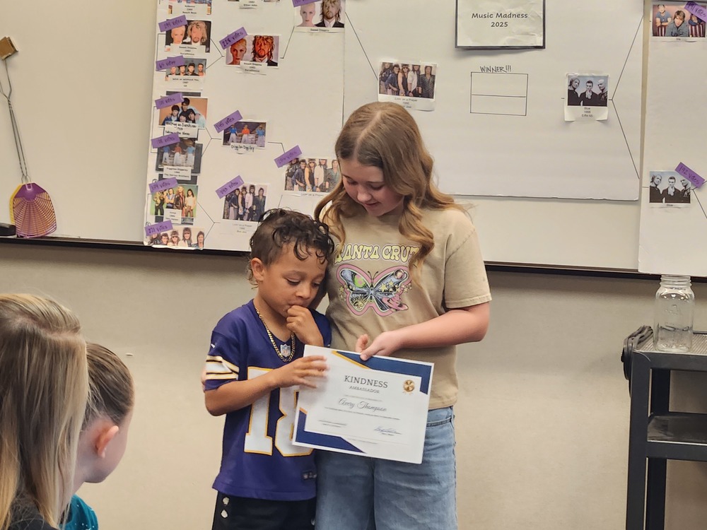 Student receiving a Kindness Ambassador Certificate from Farmington Elementary's kindness club.