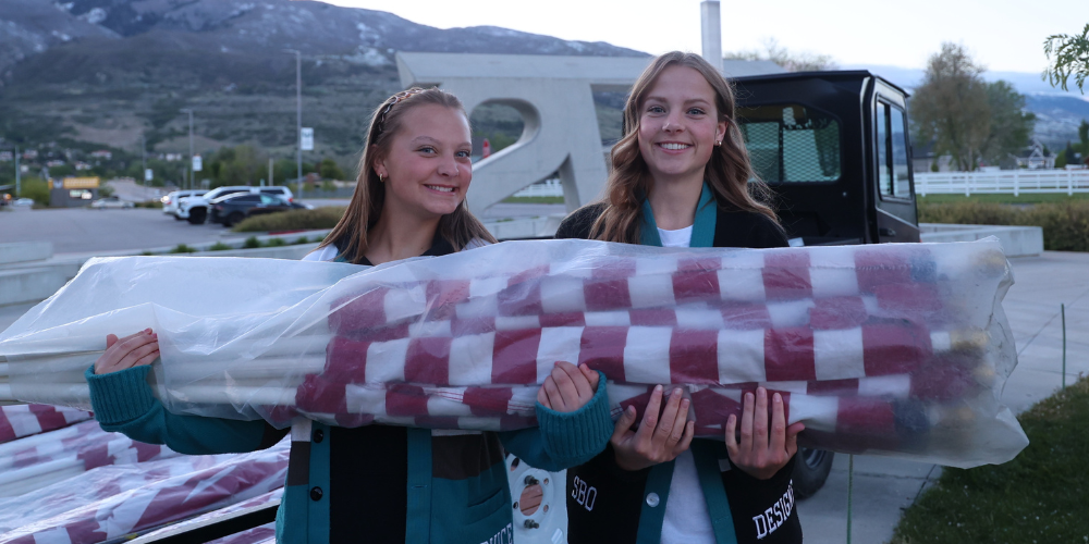 Two girls holding a bundle of flags