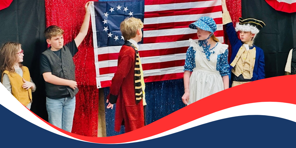 Students dressed as American Revolution leaders standing in front of an American Flag.
