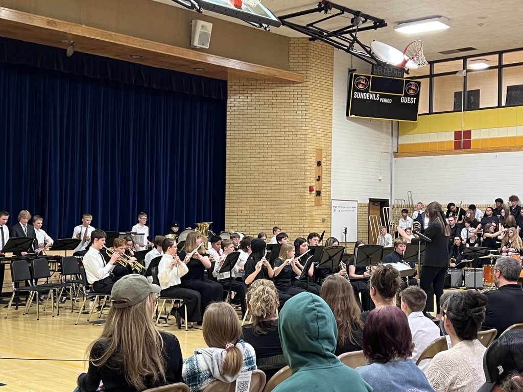 Band students in a gym playing instruments.