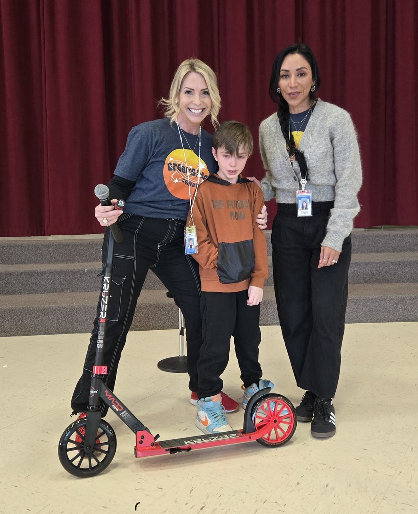 student and principals standing with scooter