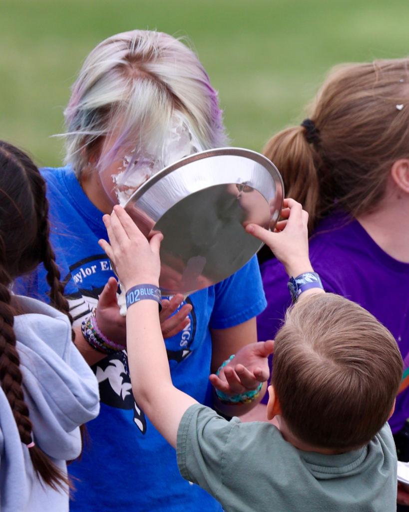 Students putting pies into teachers faces.