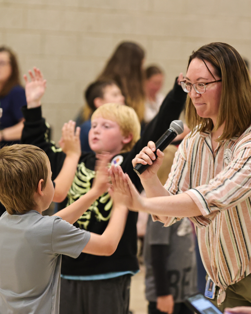 A student high fives a teacher.