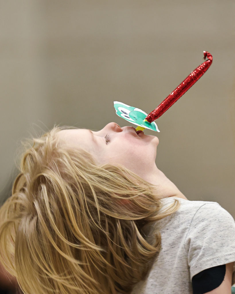 A student blows on a blow up. 