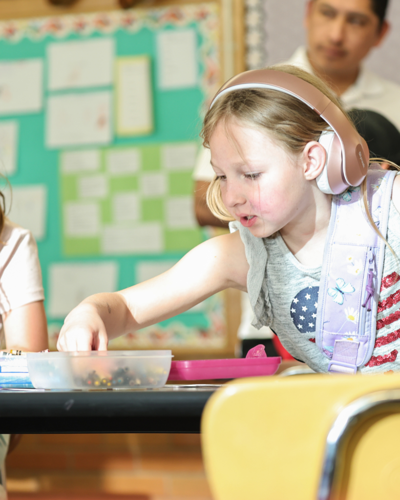 A student looks into a colored pencil box. 