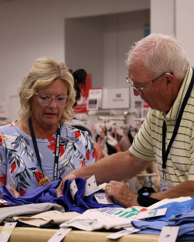 A photo of two educators going through shirts at Kohl's during Child Spree.