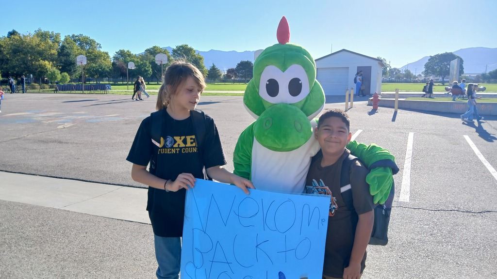 Dexter the mascot with student from student council and new 2nd grader