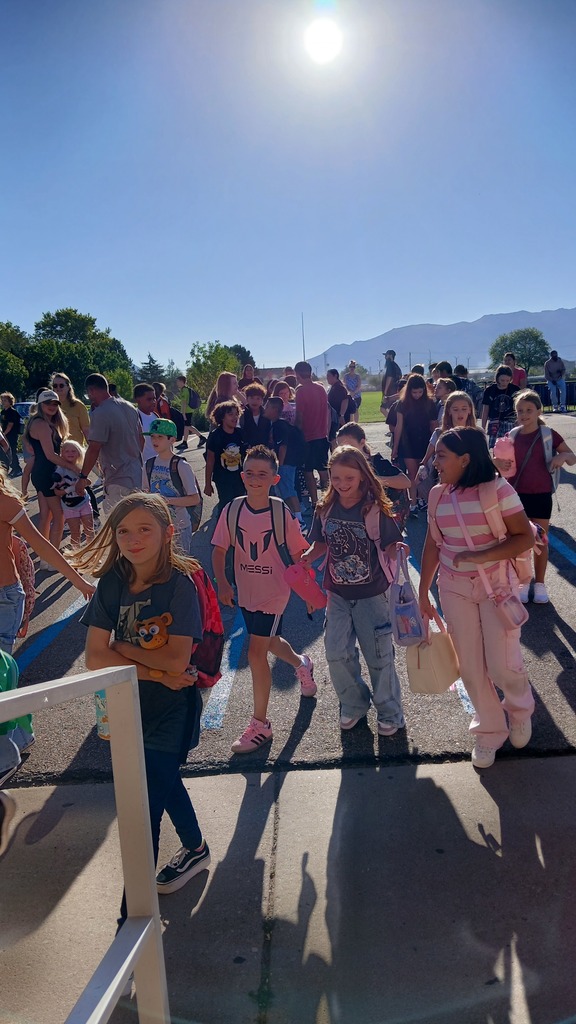 Students smiling as they walk into the school on the 1st day back.