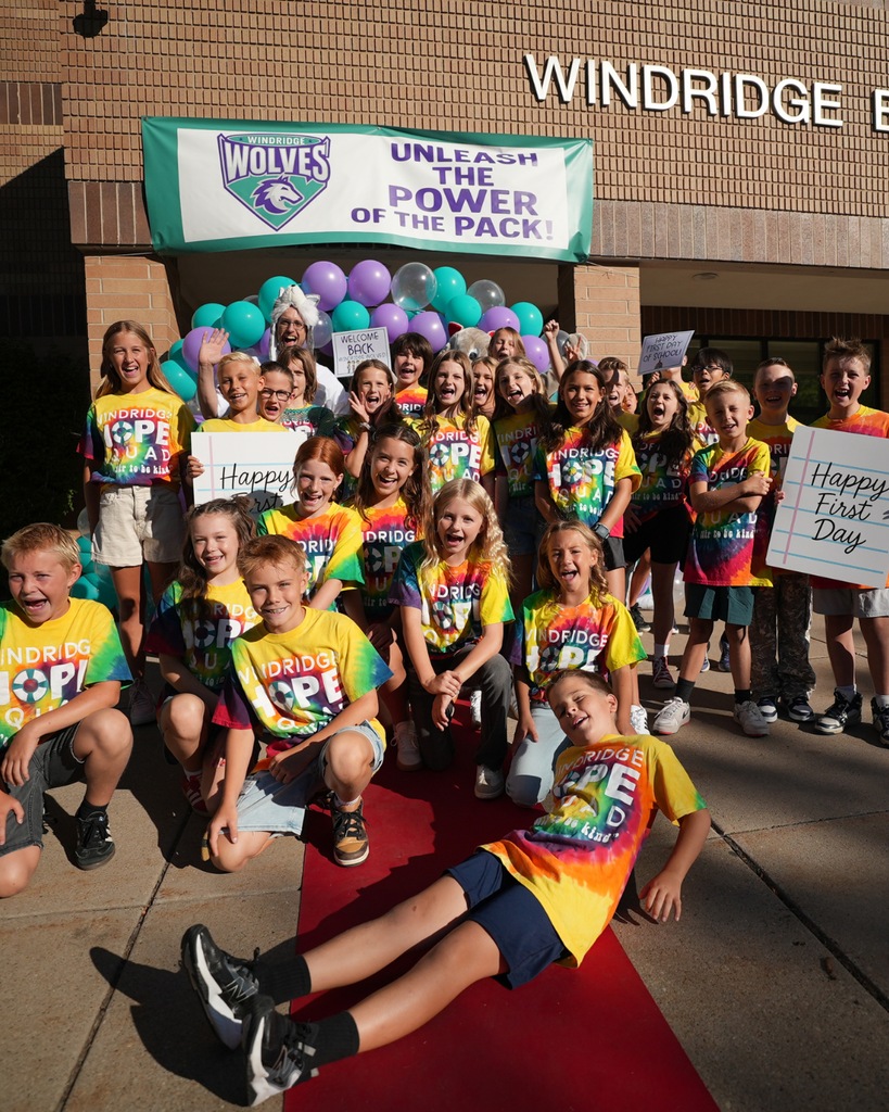 A group of hope squad members stand on a red carpet and smile at the camera.