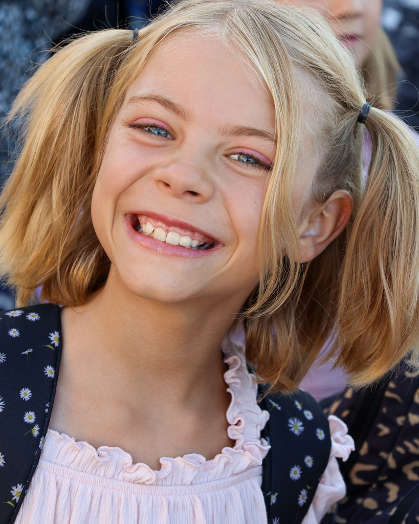 A student with pigtails smiles at the camera.