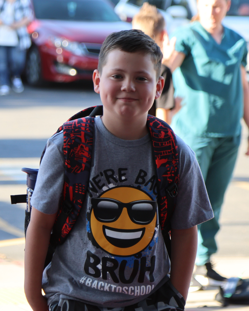 A student smiles as he comes into the school building.