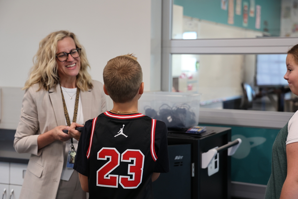 A principal talks to two students.