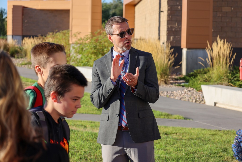 A principal clapping for students.