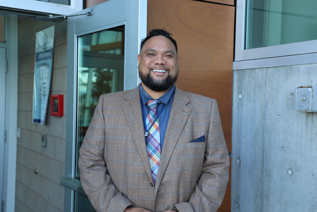 a principal smiling at the camera.