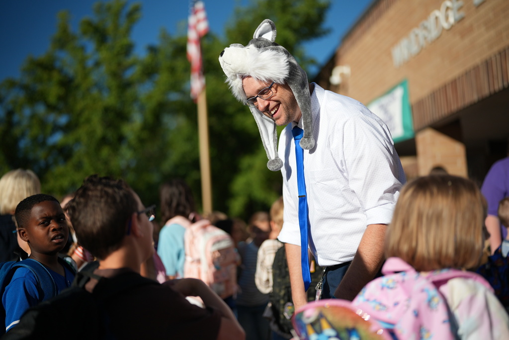 A principal talks with students.