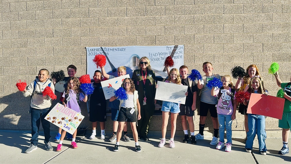 Students standing with the principal on their first day back to school. 