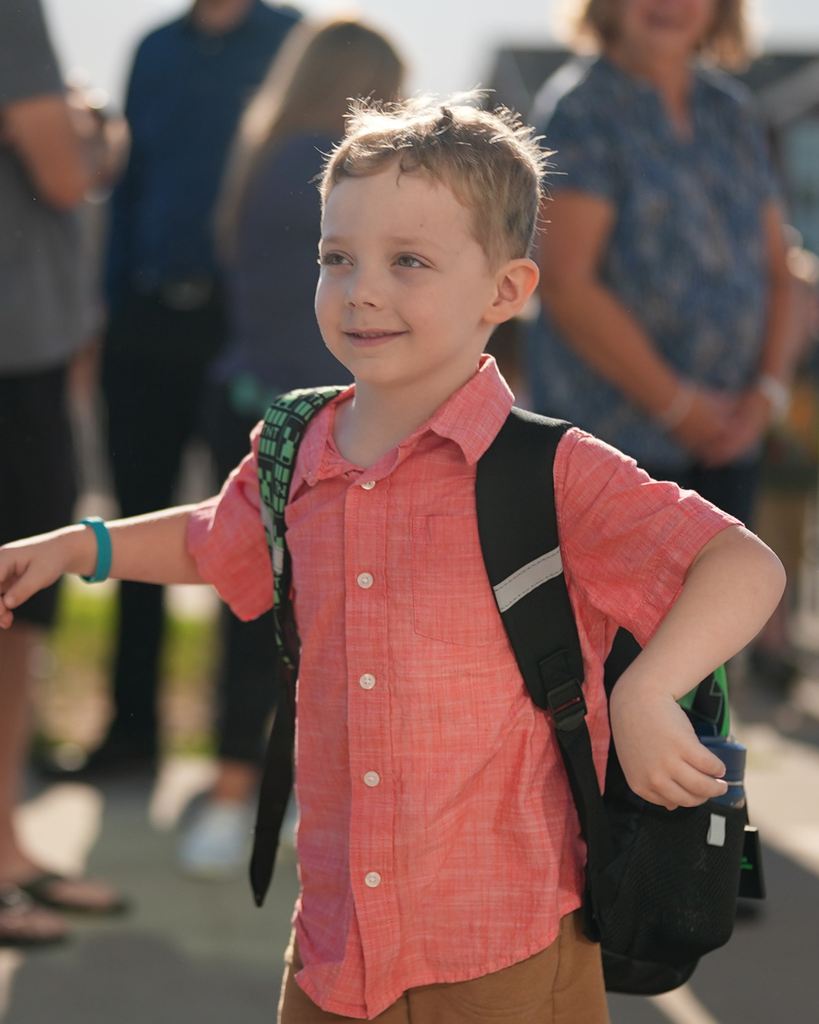 a kindergartener looking to the left and smiling.