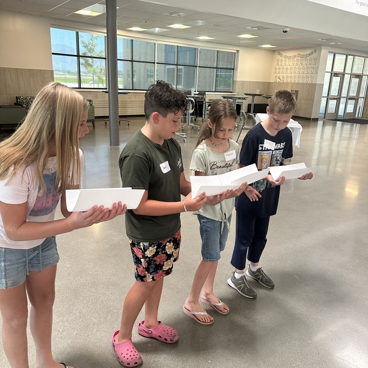group of students transfer ball with paper
