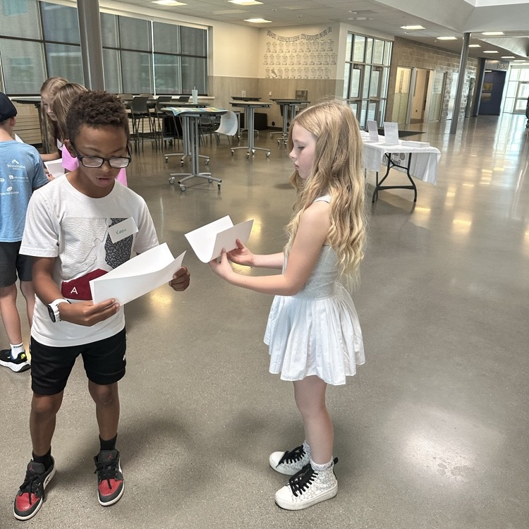 boy and girl hold papers to transfer a ball