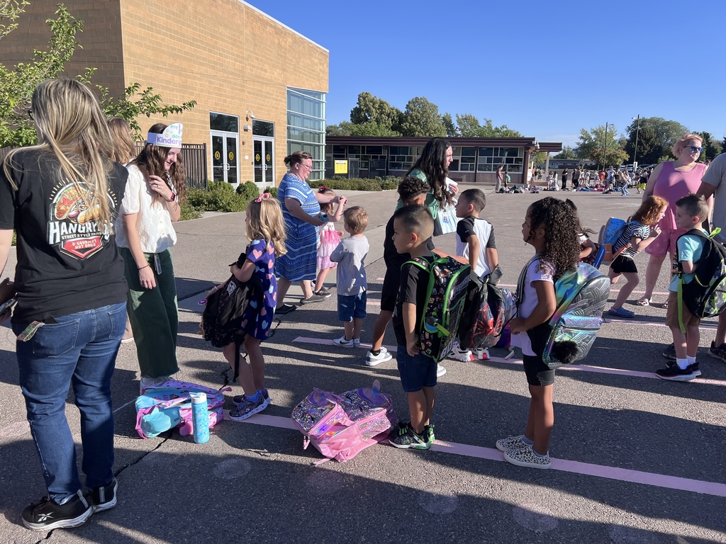 Students lining up outside of Doxey with their backpacks