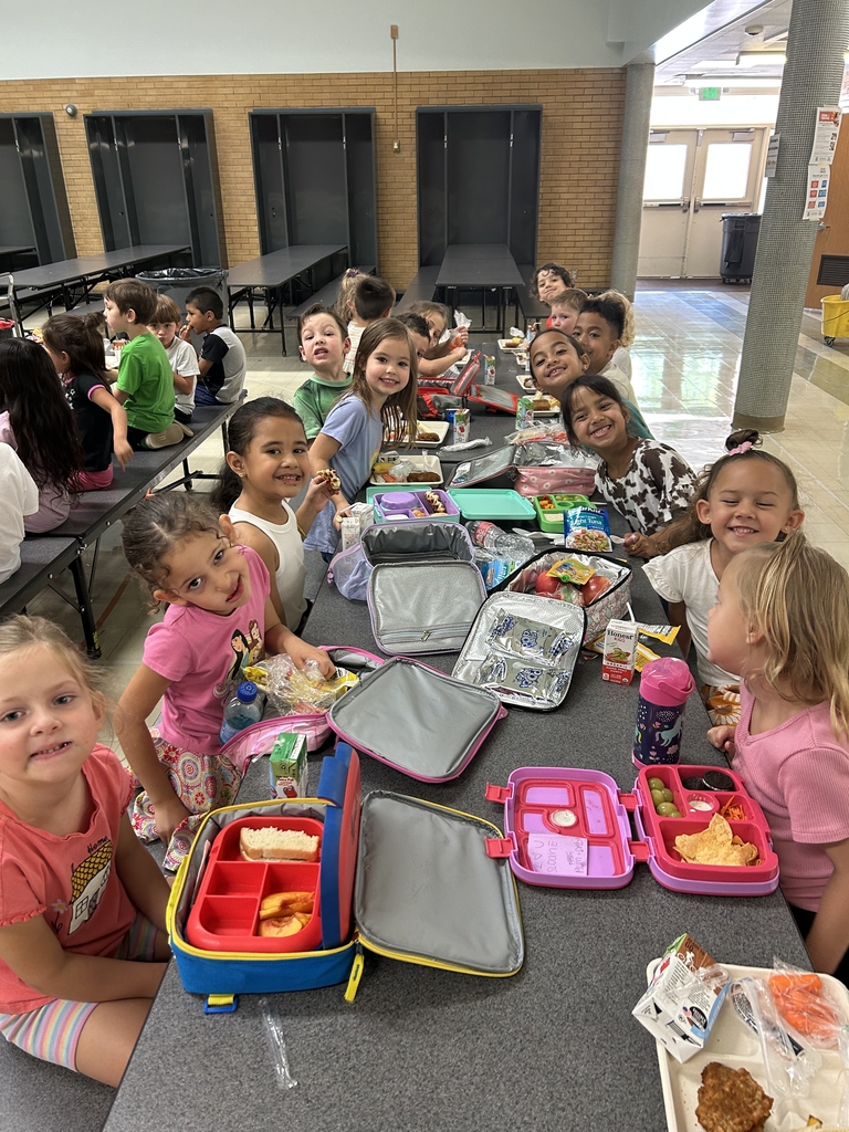 smiling students eating home and school lunches in a cafeteria
