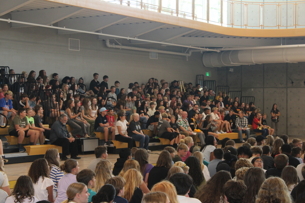 Students and teacher siting in the bleachers of Sunset Junior High's gym.