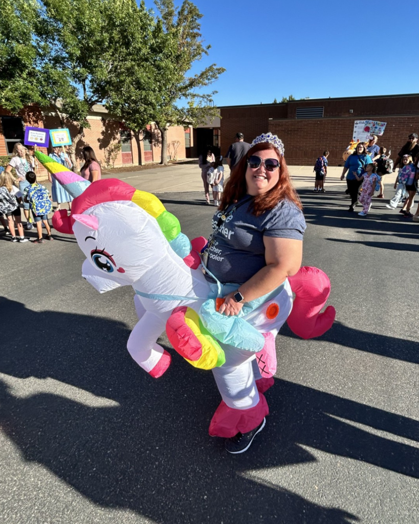 An educator wearing a blow up unicorn costume.