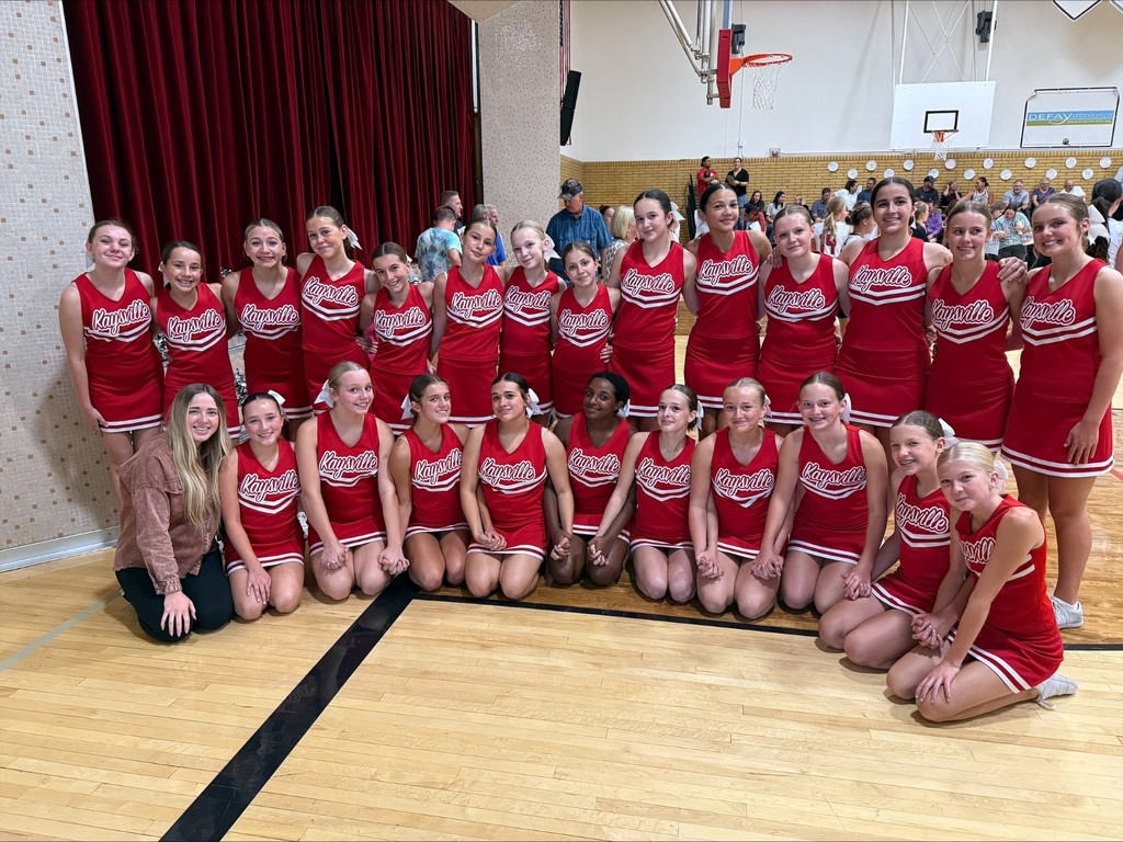 image of KJH cheerleaders posing in the KJH gym by the stage.