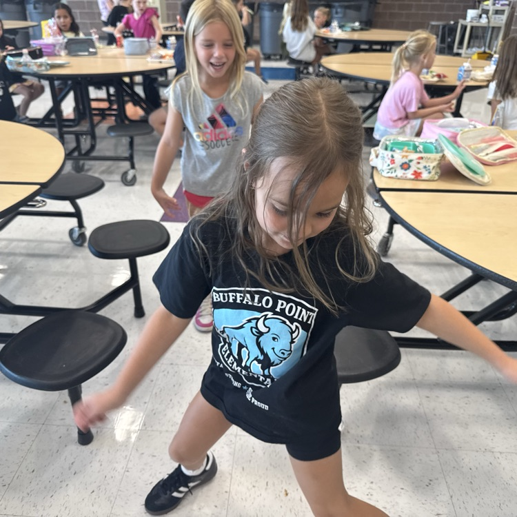 A student dancing in the cafeteria