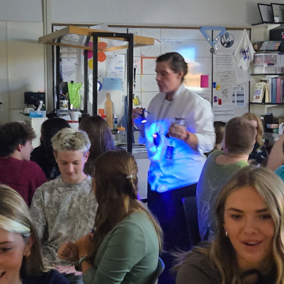 Mrs. Nettleship holding a black light to identify germs.