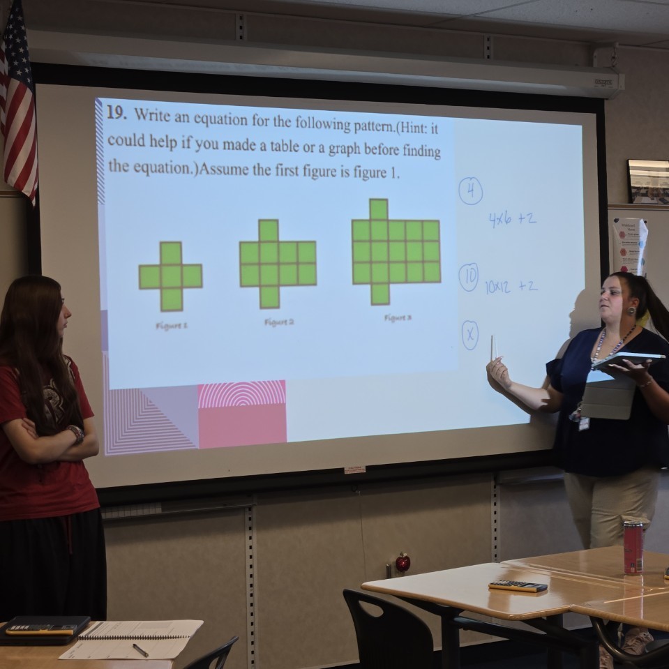 Mrs. Koskela at the board explaining to a student about mathematical patterns