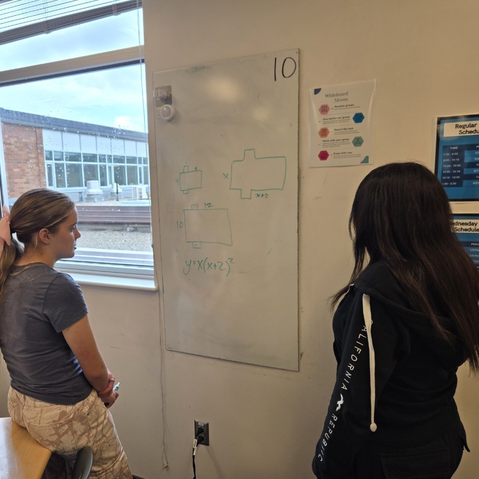 Students working on a problem on their white board.