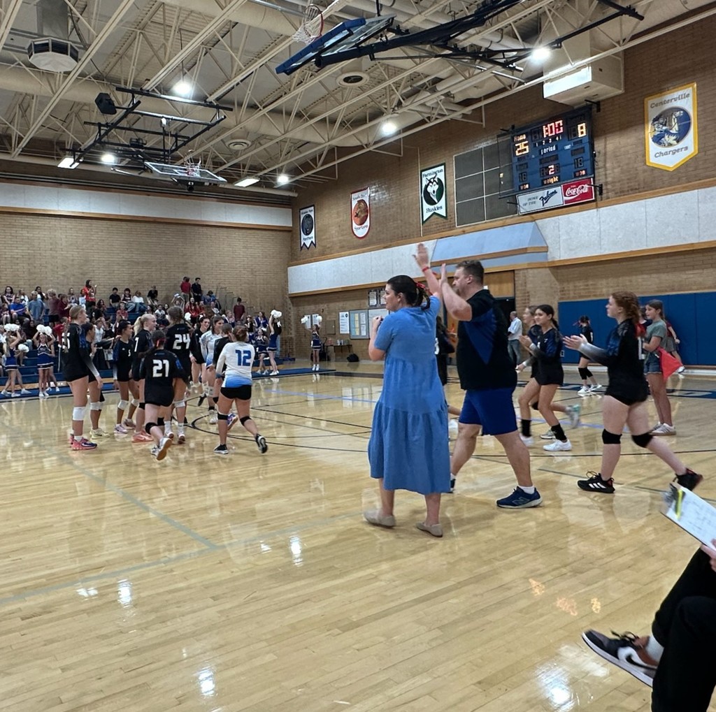 Fairfield takes the win. The girls are running onto the court while coach Vans and coach Eliason are high-fiving. In the background is the scoreboard indicating a 25-8 win.