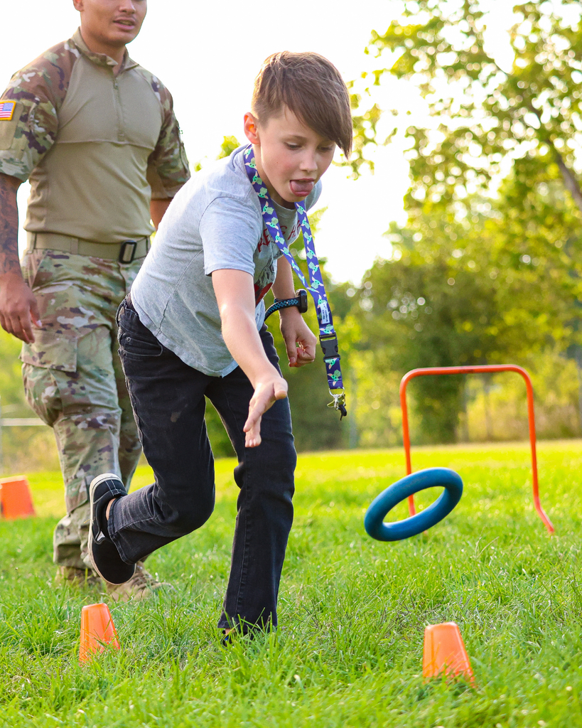 A student throwing a ring onto a cone. 